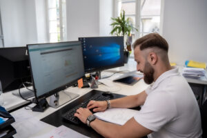 Sachbearbeiter Emre Duman erledigt den Jahresabschluss für die Kunden von Zofingen Treuhand AG am Computer.