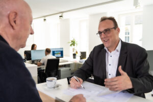 Inhaber und Steuerexperte Philippe Bally erklärt einem Kunden die Steuererklärung