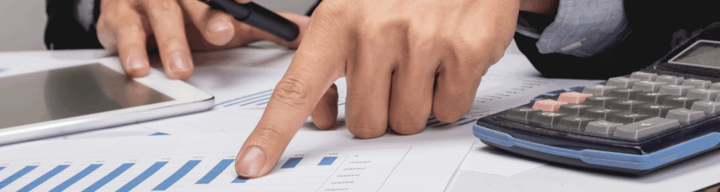 Hand zeigt auf Finanzgrafik neben Taschenrechner – Steuerplanung mit schweizer Familienstiftung und Trust