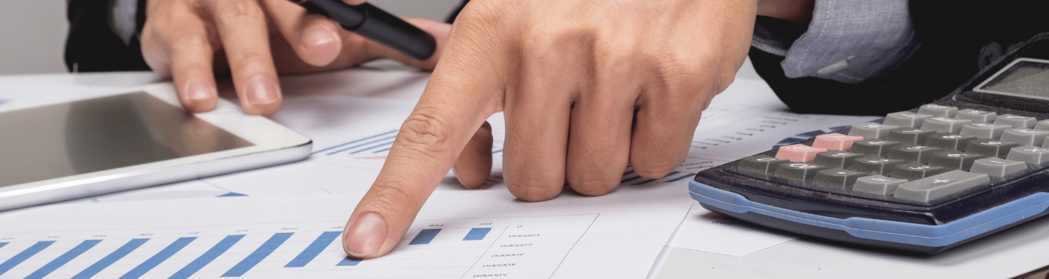 Hand zeigt auf Finanzgrafik neben Taschenrechner – Steuerplanung mit schweizer Familienstiftung und Trust